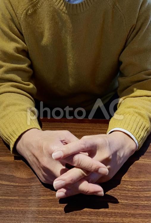 テーブルの上で手を組む中年男性 テーブル,手,シニアの写真素材