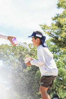 水遊びで顔に水をかけられそうな男の子 水遊びで顔に水をかけられそうな男の子の写真