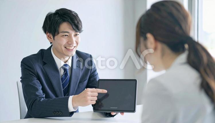 タブレットを使って説明する男性営業マン タブレット,男性営業マン,男性ビジネスマンの写真素材
