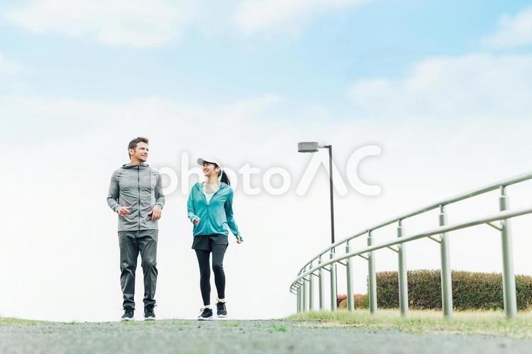公園で景色を見ながらウォーキングする男女 ウォーキング,運動,歩くの写真素材