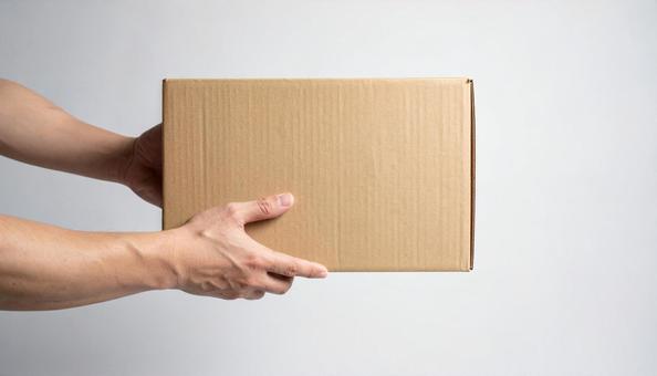 段ボールを運ぶ男性の手の写真