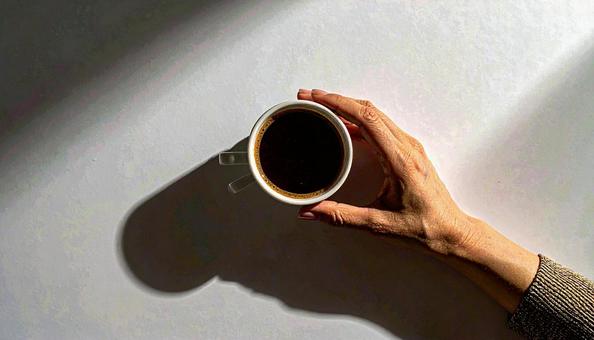 コーヒーカップを手にする女性の手 コーヒーカップを手にする女性の手の写真