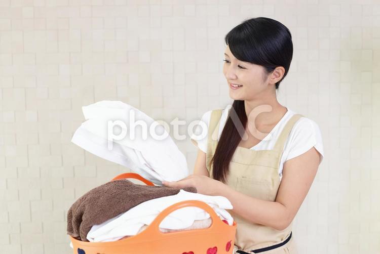 洗濯物を持つ笑顔の主婦 女性,主婦,母親の写真素材