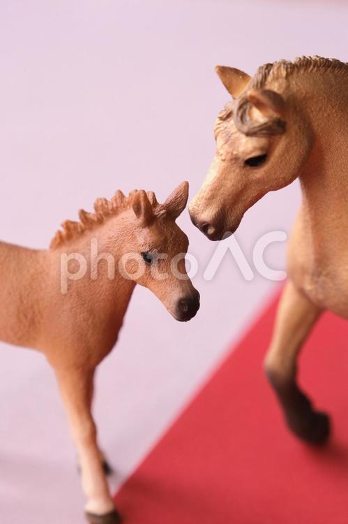 シュライヒ　ピンクと赤の背景に見つめ合う馬の親子フィギュア シュライヒ,シュライヒフィギュア,馬の写真素材