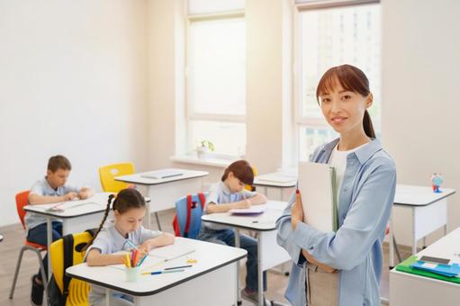 腕を組んでカメラ目線の先生と勉強する生徒たちと太陽 女性,女の子,男の子の写真素材