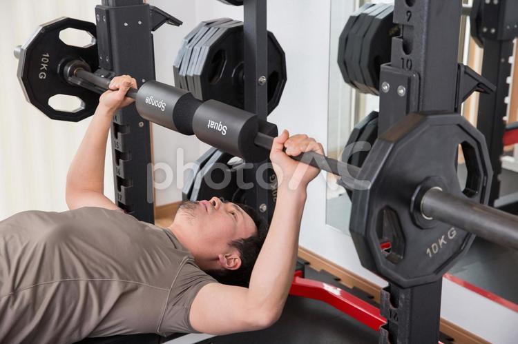 スポーツジムでバーベルをあげる男性 バーベル,ベンチプレス,筋トレの写真素材