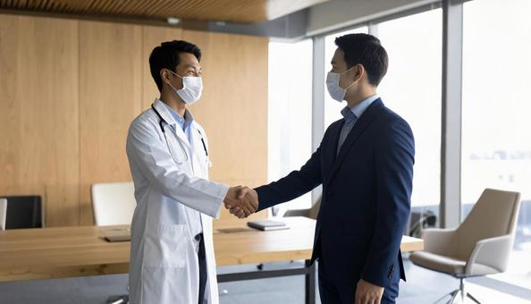 社員と医者 握手の写真