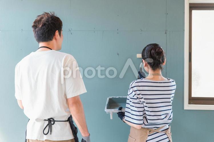 壁の塗装をする日本人の男女の後ろ姿 塗装,ペンキ,diyの写真素材