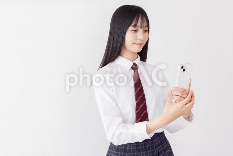 スマートフォンで志望校を調べる女子高生 女性,女子高生,高校生の写真素材