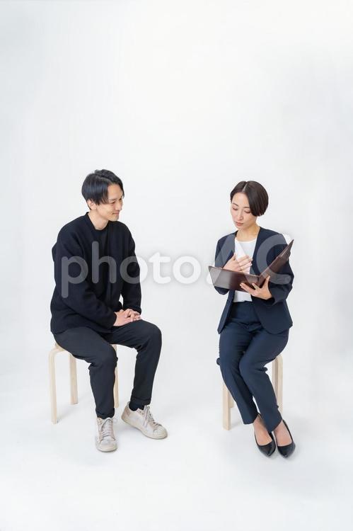 スーツを着た女性と話す私服の男性 打合せ,男性,ビジネスの写真素材
