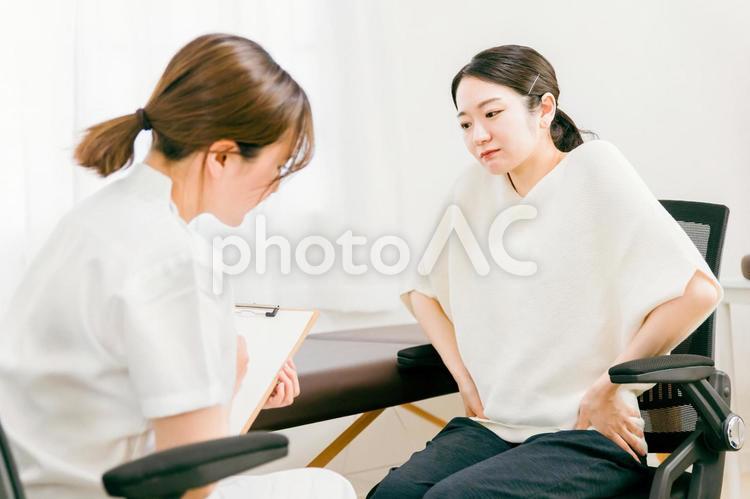 骨盤痛で悩む女性を診察する医師（整骨） 骨盤矯正,骨盤痛,骨盤の写真素材
