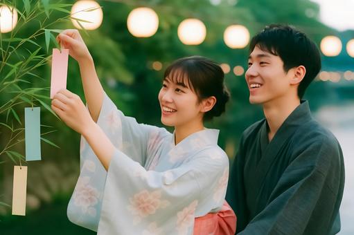短冊を飾る浴衣の男女の写真