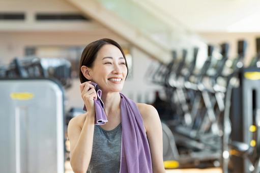 ジムでトレーニングするミドルの女性の写真