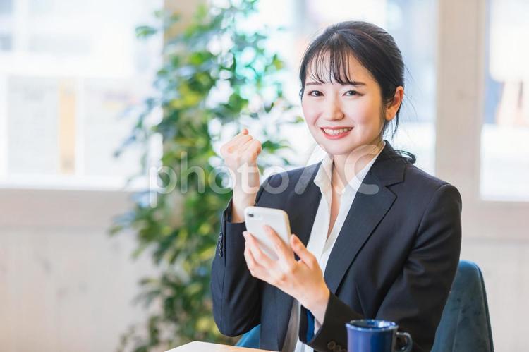 スマホを使うスーツ姿の女性・ビジネスウーマン スマートフォン,スマホ,アプリの写真素材