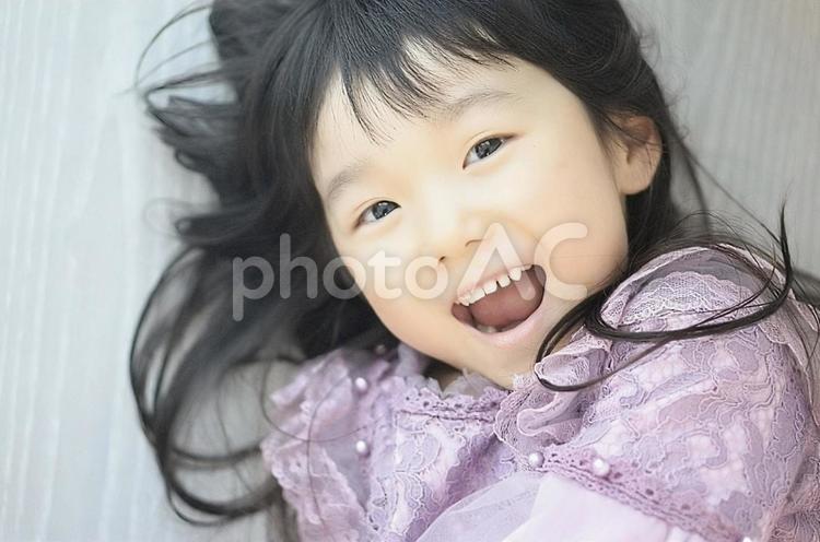 寝転がる笑顔の女の子 笑顔,子供,女の子の写真素材