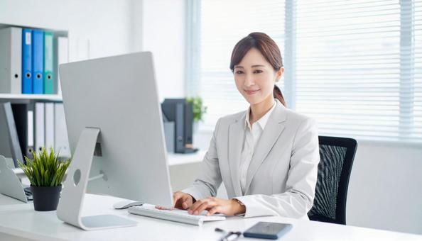 オフィスでパソコン使用した仕事をする女性 オフィスでパソコン使用した仕事をする女性の写真