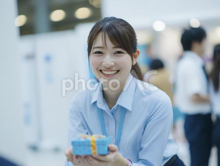 プレゼントを差し出すシャツ姿の女性 女性,ビジネス,プレゼントの写真素材