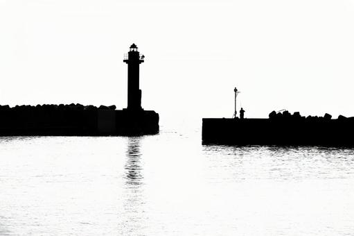 灯台と防波堤のシルエット 灯台と防波堤のシルエットの写真