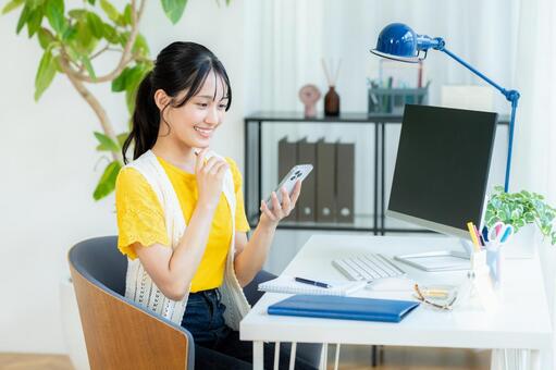 スマホを操作する若い女性 ビジネスウーマン,若い女性,笑顔の写真素材