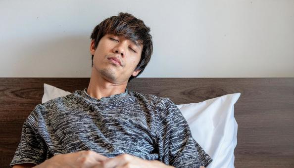 朝起きて低血圧でぼんやりしている男性 朝起きて低血圧でぼんやりしている男性の写真