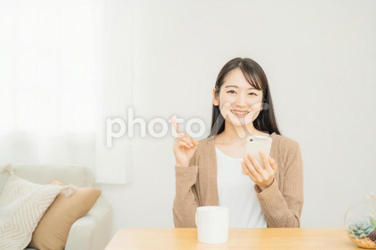家でスマホを使う女性 スマホ,スマートフォン,笑顔の写真素材