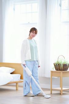 カメラ目線で掃除機を持つ女性の写真