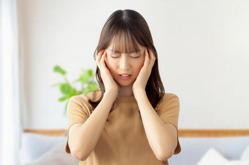 頭を押さえて悩む女性 女性,悩む,困るの写真素材