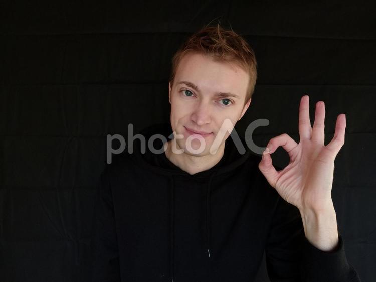 OK　オッケーとジェスチャーで表している外国人男性　黒バック ok,オッケー,合図の写真素材