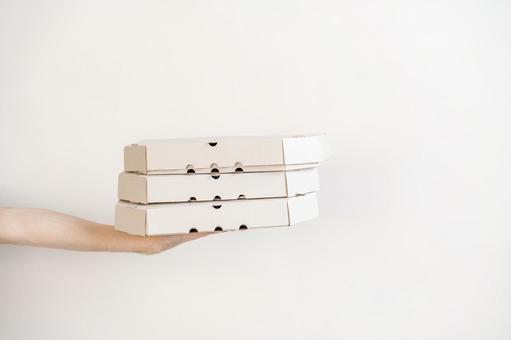 3箱のピザ箱を差し出す手 配達,フードデリバリー,テイクアウトの写真素材