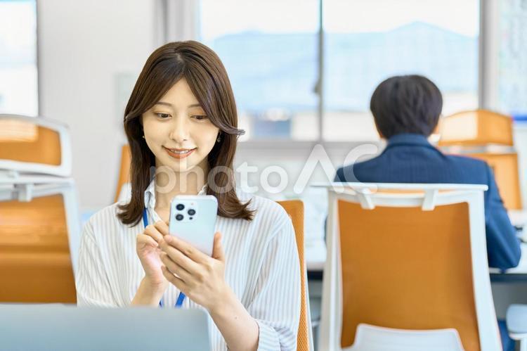 スマホを見るビジネスウーマン　会社 ビジネスウーマン,スマホ,笑顔の写真素材
