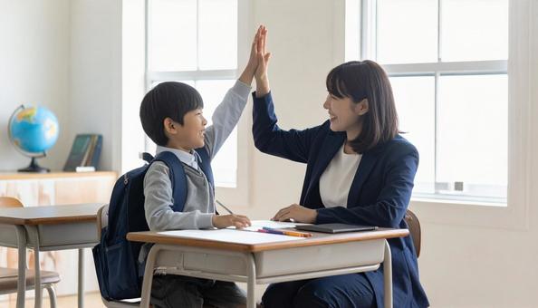 ハイタッチする塾講師と小学生の男の子 ハイタッチする塾講師と小学生の男の子の写真