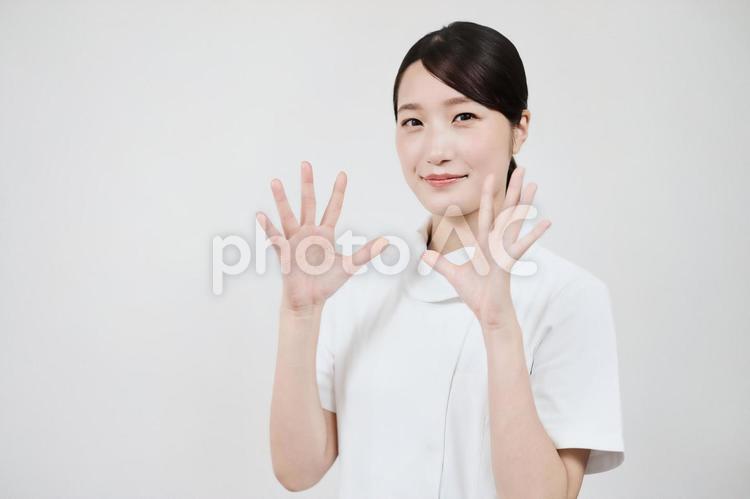 安心を与えるポーズをする白衣の女性  看護師,白衣,介護士の写真素材