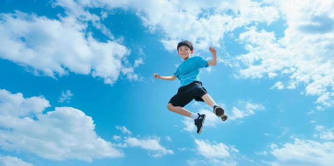 青空に向かってジャンプする男子 青空に向かってジャンプする男子の写真