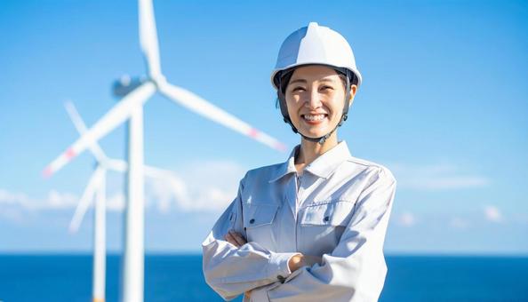 風力発電所で笑顔の作業服を着た若い女性 風力発電所で笑顔の作業服を着た若い女性の写真