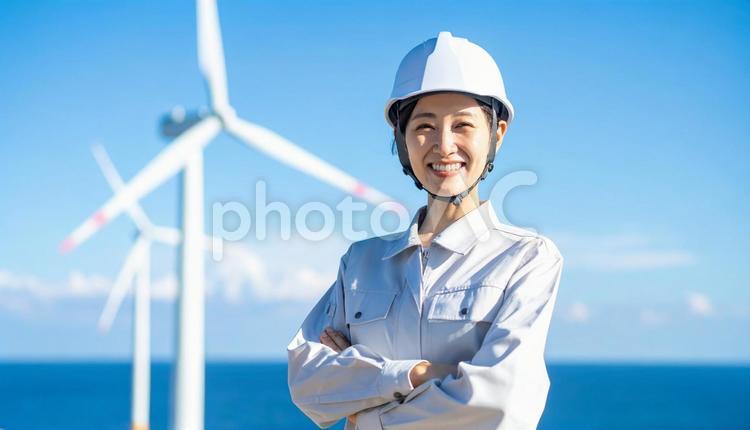 風力発電所で笑顔の作業服を着た若い女性 人物,女性,作業服の写真素材