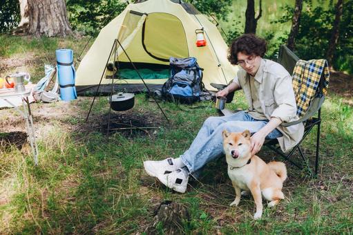 テント前で犬を見守る男性 男性,外国人,犬の写真素材