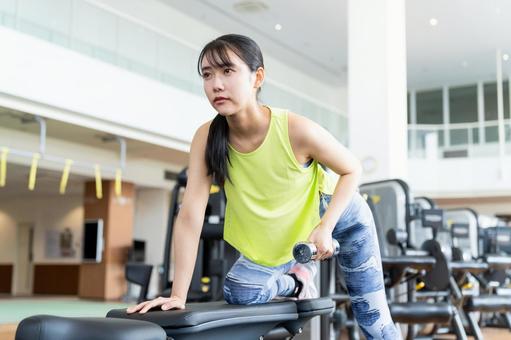 ジムでトレーニングする若い女性 ジム,フィットネス,ボディケアの写真素材