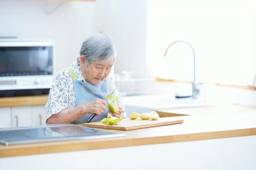 リンゴの皮むきをしている高齢女性 女性,リンゴ,皮むきの写真素材