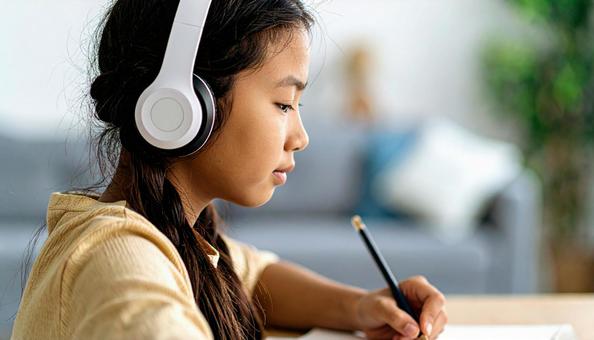 お気に入りの音楽を聴きながら勉強する女性 お気に入りの音楽を聴きながら勉強する女性の写真