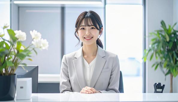笑顔で対応する女性の受付嬢 笑顔で対応する女性の受付嬢の写真