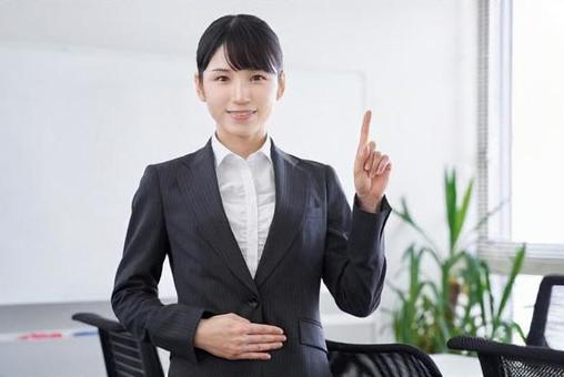 Japanese female business woman giving an explanation by pointing at the office Japanese female business woman giving an explanation by pointing at the office