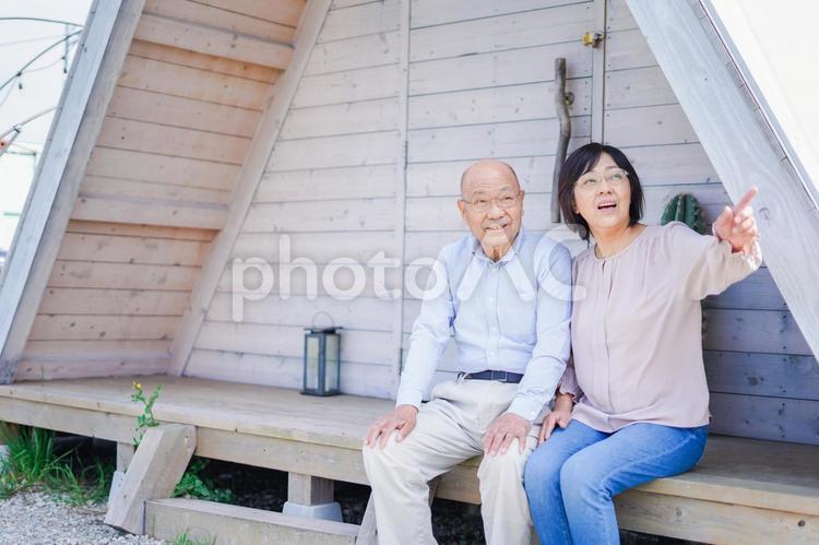 別荘の前に座るシニアの夫婦 くつろいで,リラックス,リラクゼーションの写真素材