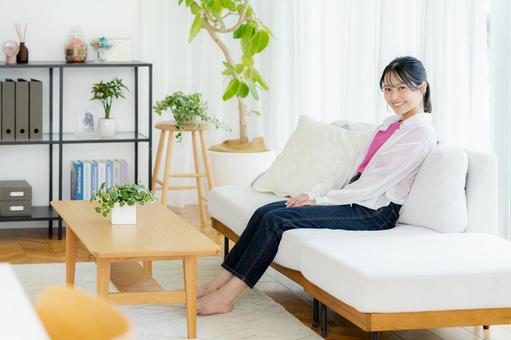 リビングでくつろぐ若い女性の写真