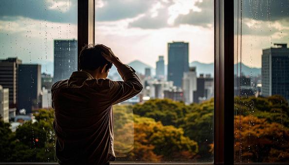 頭を抱えて落ち込む日本人男性 頭を抱えて落ち込む日本人男性の写真
