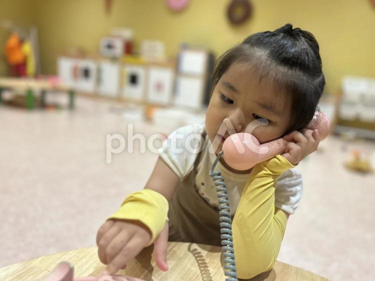 子供用のおもちゃの電話で遊ぶ女の子 子供,女の子,電話の写真素材