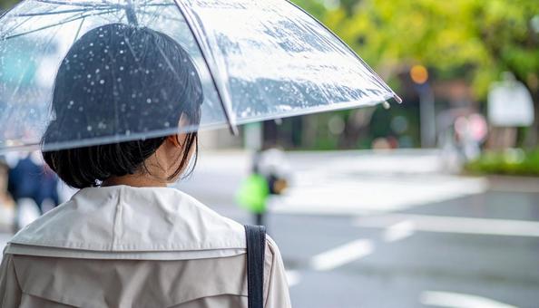 雨の中バス停でバスを待つ日本人女性 雨の中バス停でバスを待つ日本人女性の写真