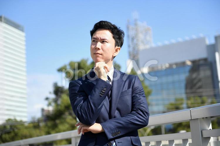 屋外で悩むアジア人のビジネスマンの男性 ビジネスマン,男性,ビジネスの写真素材