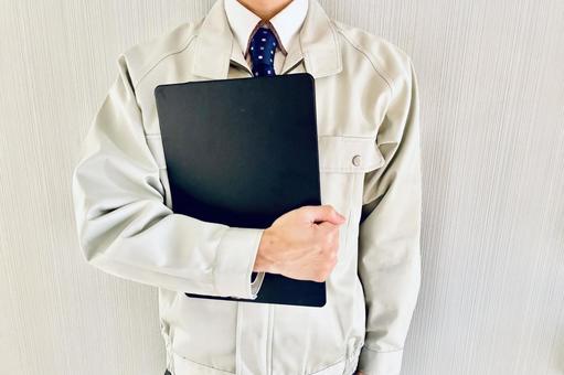 バインダーを持つ作業着の男性ビジネスマン 作業員,人物,男性の写真素材