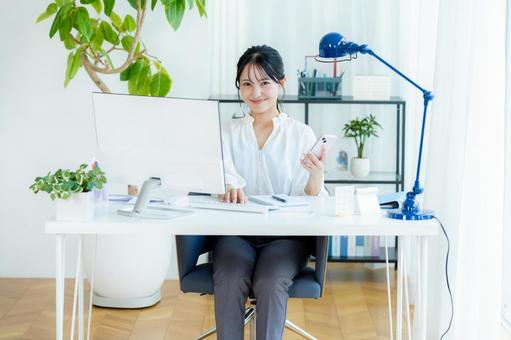 オフィスでスマホを持つビジネスウーマン スマホ,笑顔,ビジネスウーマンの写真素材