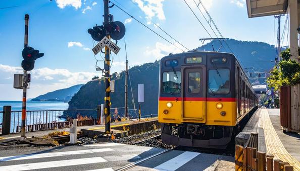 駅の踏切を走る電車 駅の踏切を走る電車の写真